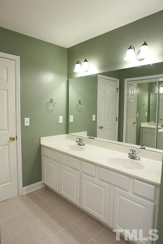 5425 Goldenglow Way Raleigh, NC 27606 - Photo 14 of 17 a bathroom with a double vanity sink and a mirror