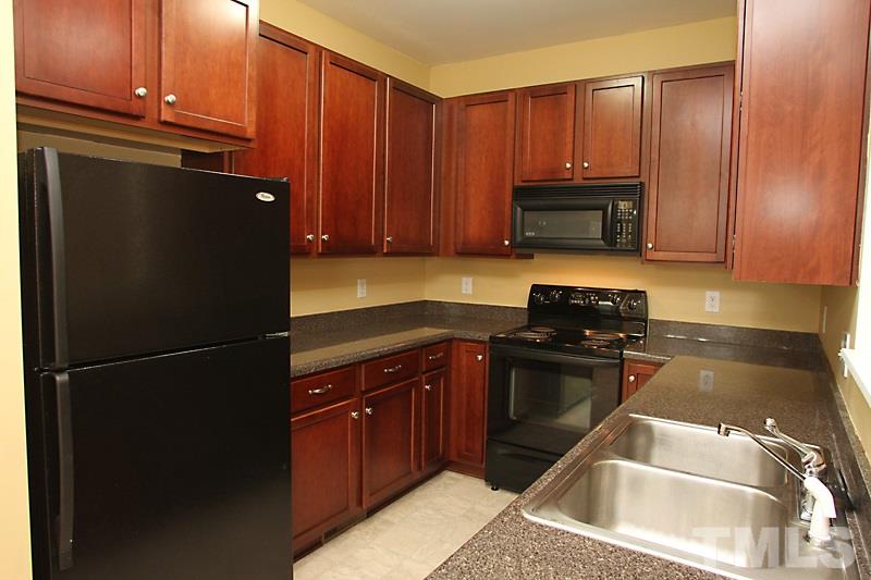 5425 Goldenglow Way Raleigh, NC 27606 - Photo 5 of 17 a kitchen with a refrigerator stove and cabinets