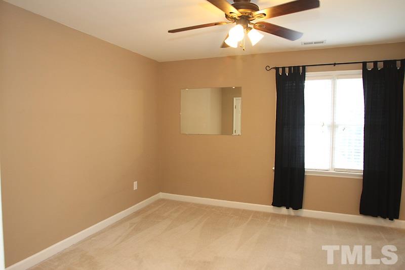 5425 Goldenglow Way Raleigh, NC 27606 - Photo 8 of 17 an empty room with a window and a fan