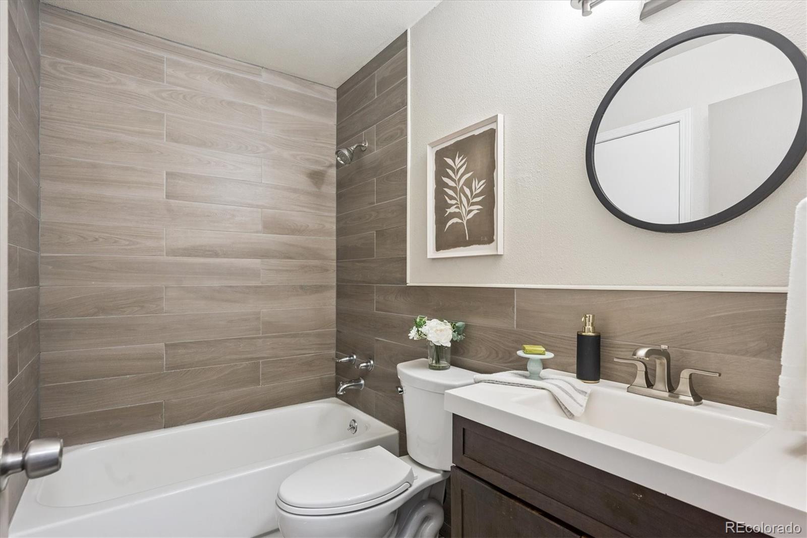 669 Walden Court Highlands Ranch, CO 80126 - Photo 19 of 34 a bathroom with a sink a toilet and a mirror