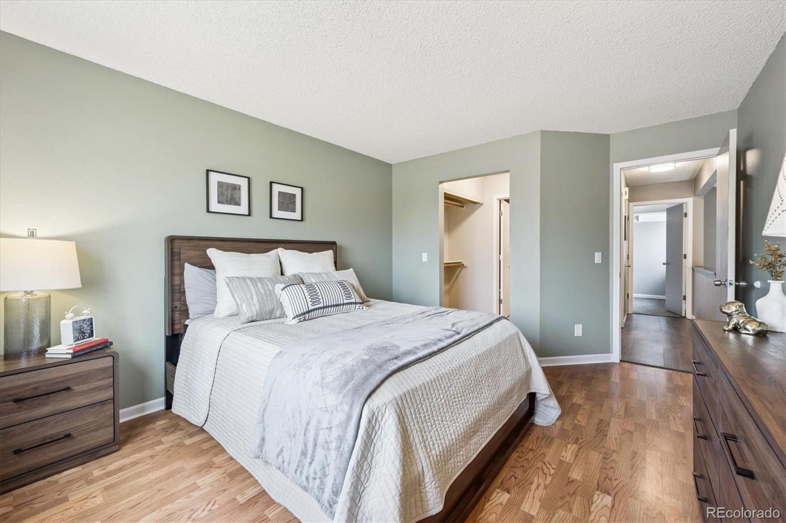 669 Walden Court Highlands Ranch, CO 80126 - Photo 22 of 34 a spacious bedroom with a bed and a lamp
