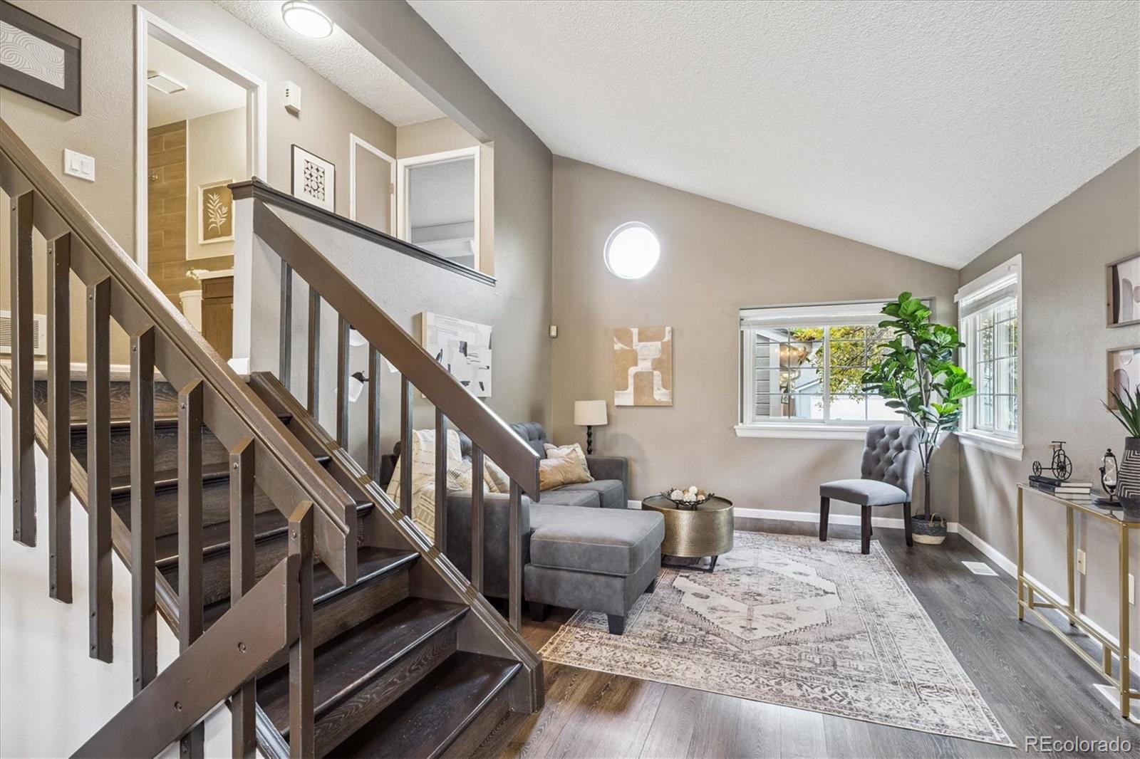 669 Walden Court Highlands Ranch, CO 80126 - Photo 5 of 34 a living room with furniture and a dining table with wooden floor
