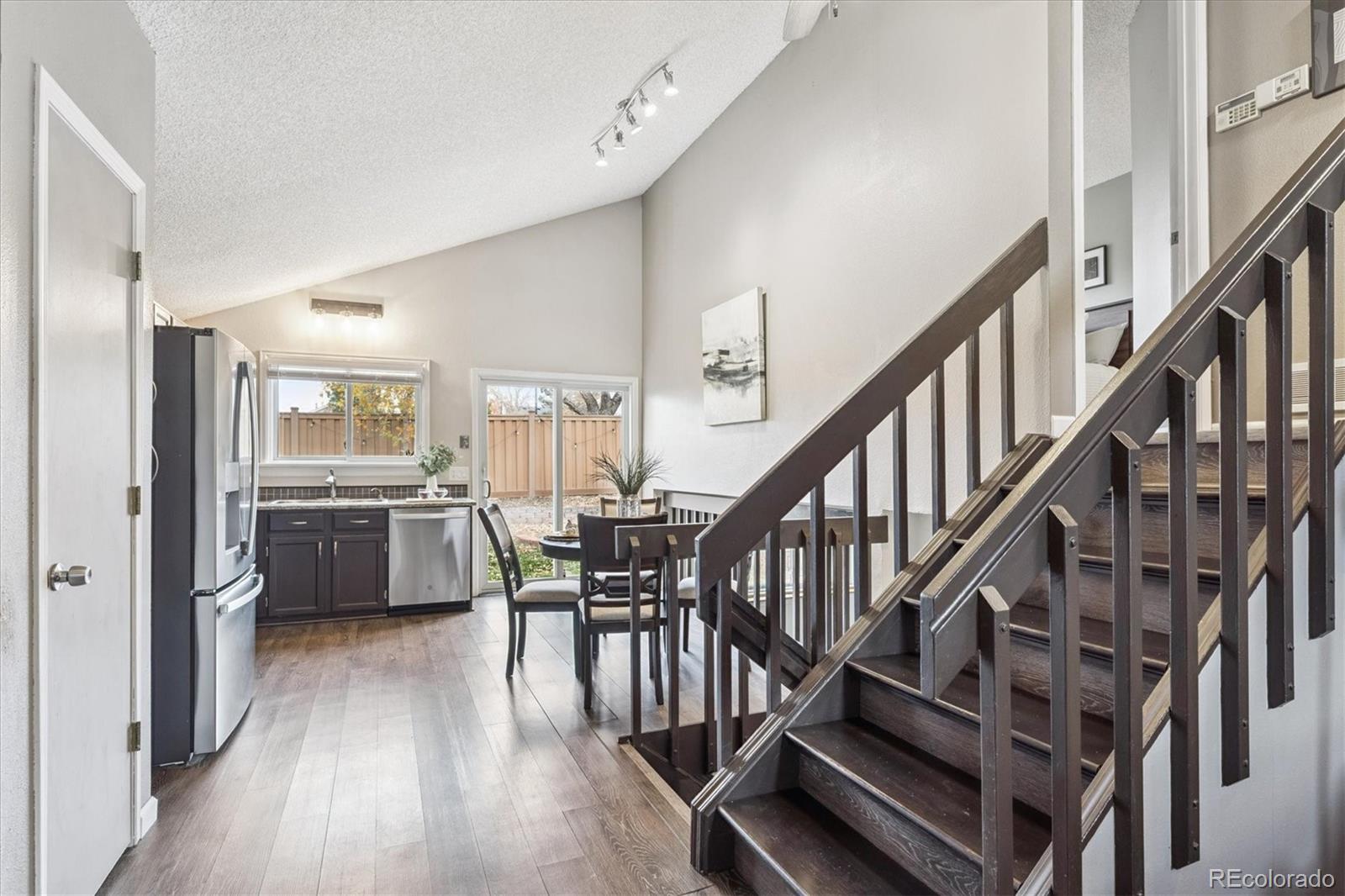 669 Walden Court Highlands Ranch, CO 80126 - Photo 6 of 34 a view of a hallway with wooden floor and a kitchen view