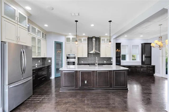 a large kitchen with granite countertop a large counter top stainless steel appliances and cabinets