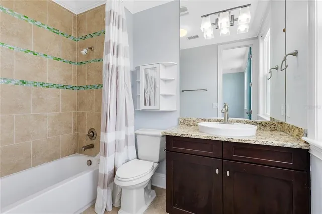 a bathroom with a granite countertop sink toilet mirror and bathtub