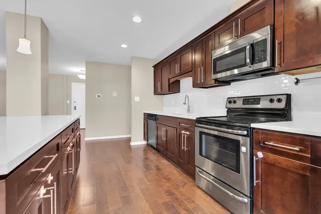a kitchen with stainless steel appliances granite countertop a stove a microwave and a hard wood floors