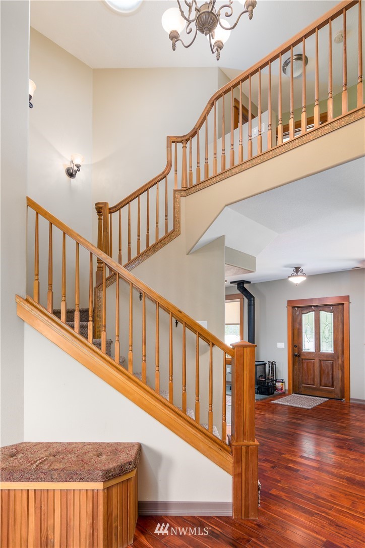 6845 Willow Grove Road Longview, WA 98632 - Photo 2 of 30 a view of staircase with lots of frames on wall and wooden floor