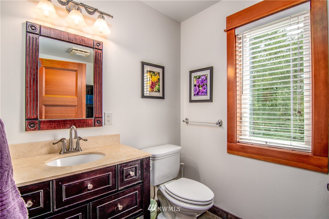 6845 Willow Grove Road Longview, WA 98632 - Photo 19 of 30 a bathroom with a granite countertop toilet a sink and a window