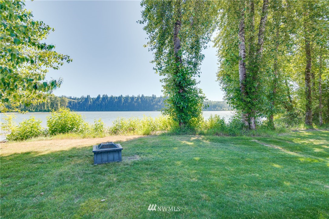 6845 Willow Grove Road Longview, WA 98632 - Photo 24 of 30 a view of a lake with a yard and palm trees