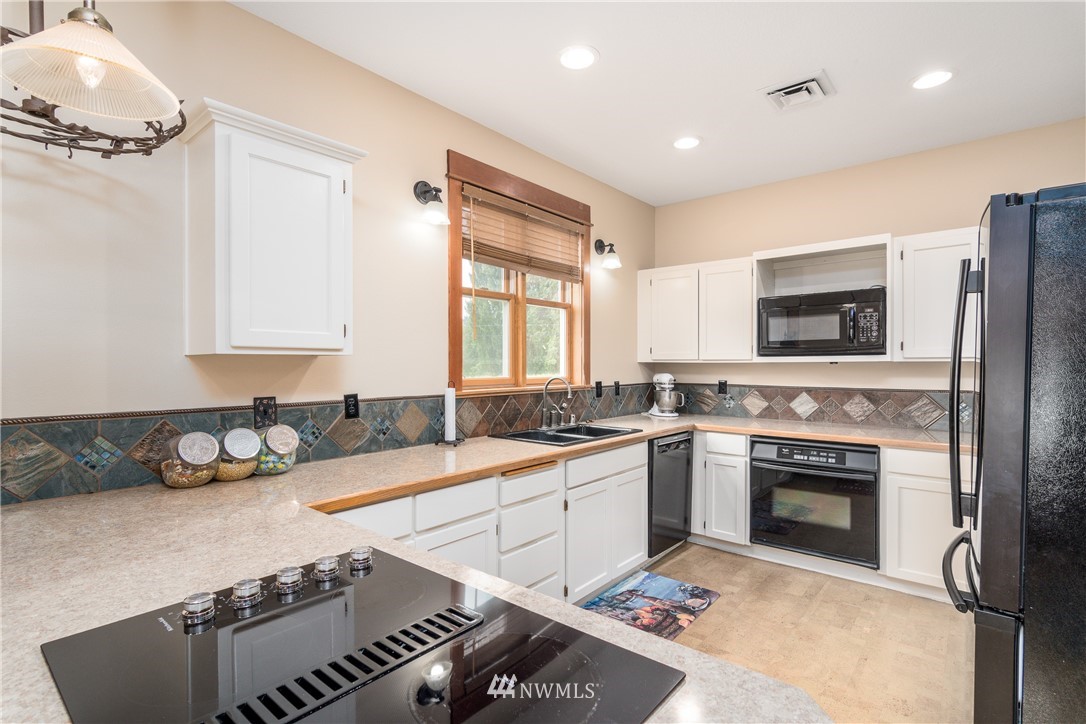 6845 Willow Grove Road Longview, WA 98632 - Photo 5 of 30 a kitchen with a stove a sink and a refrigerator