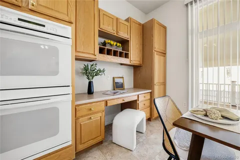 a living room with furniture cabinets and a potted plant