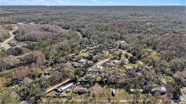an aerial view of house with yard and mountain view in back