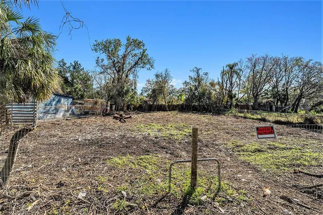 a view of a yard with wooden fence