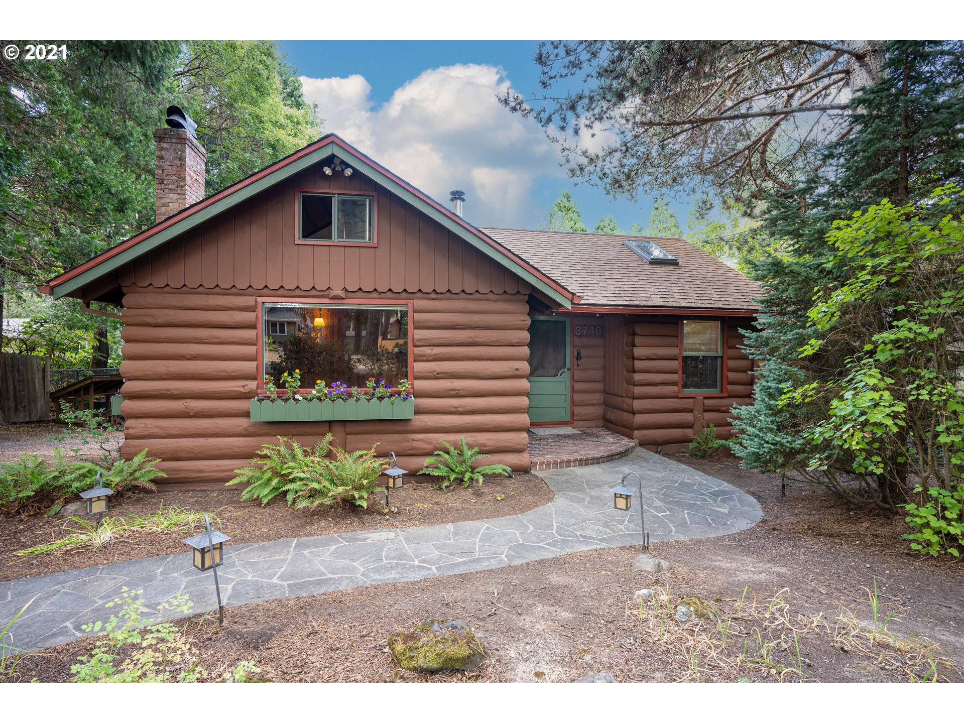 3740 Southwest Caldew Street Portland, OR 97219 - Photo 2 of 28 a front view of a house with a yard and garage