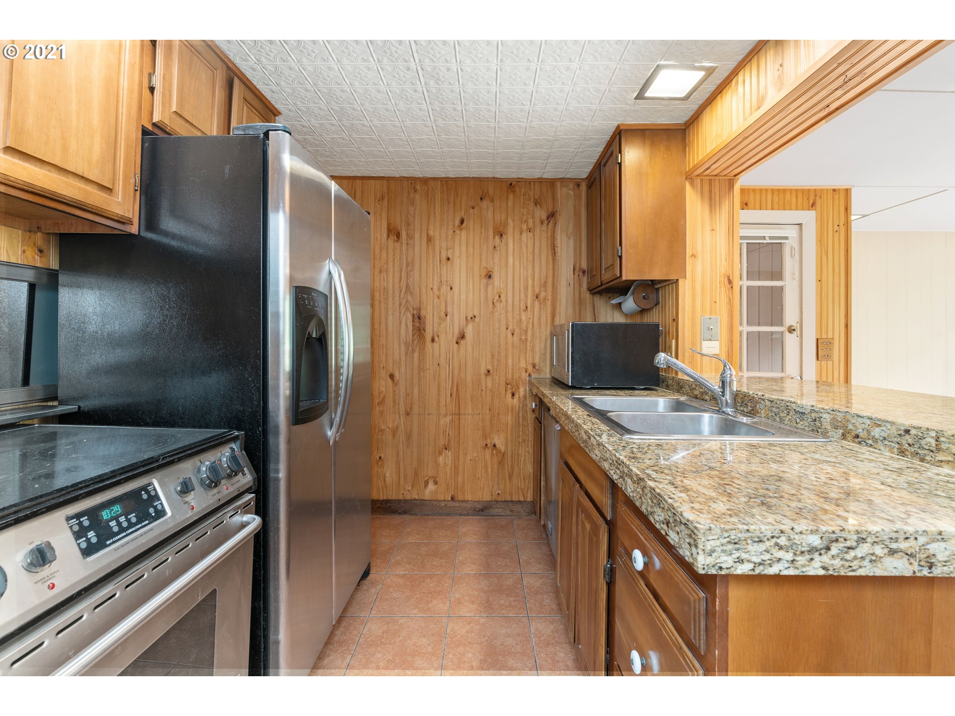 3740 Southwest Caldew Street Portland, OR 97219 - Photo 17 of 28 a kitchen with granite countertop a sink stove and refrigerator
