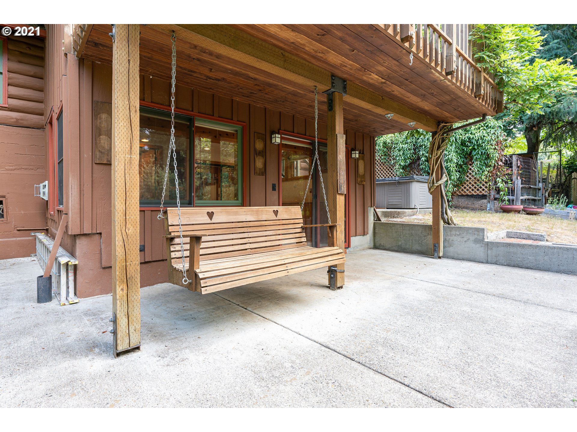 3740 Southwest Caldew Street Portland, OR 97219 - Photo 21 of 28 a view of a patio with a table and chairs under an umbrella with a small yard