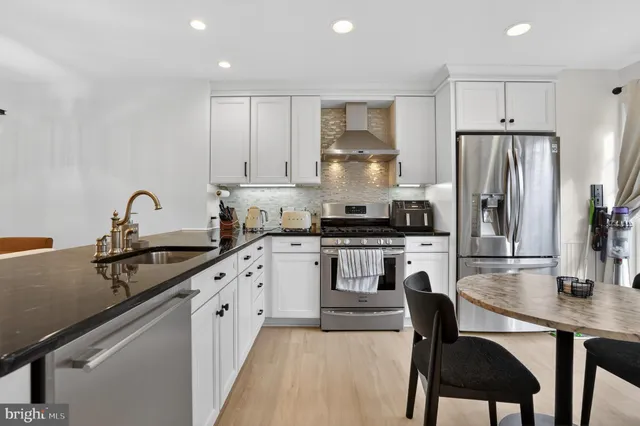 a kitchen with a stove a sink a refrigerator and cabinets