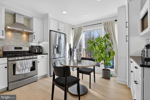 a kitchen with stainless steel appliances a kitchen island hardwood floor sink and stove