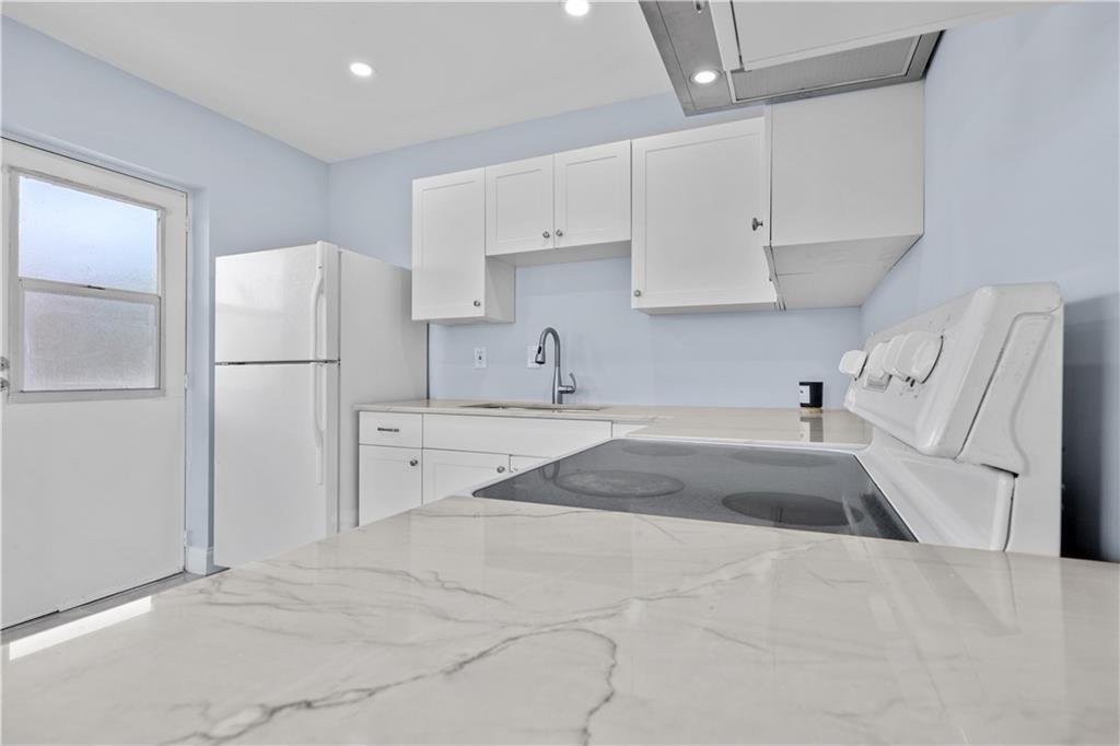 260 Northwest 19th Street, Unit 290 Boca Raton, FL 33432 - Photo 9 of 18 a kitchen with white cabinets and refrigerator