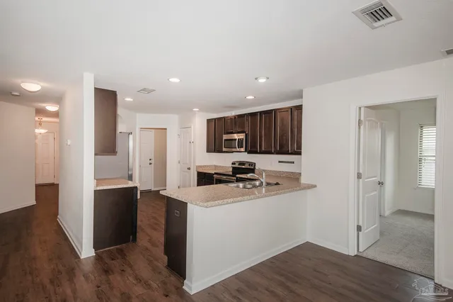 a kitchen with stainless steel appliances a refrigerator and a stove top oven