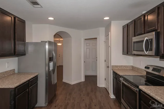 a kitchen with granite countertop stainless steel appliances and wooden cabinets