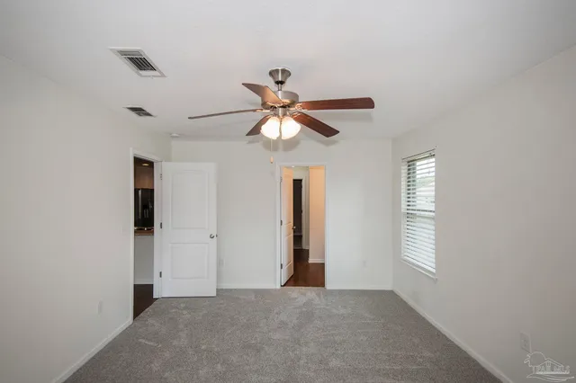 an empty room with closet and windows