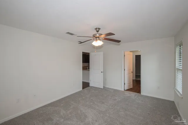 a view of a livingroom with a ceiling fan and window