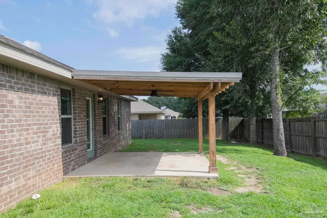 a view of a patio with a table and chairs under an umbrella