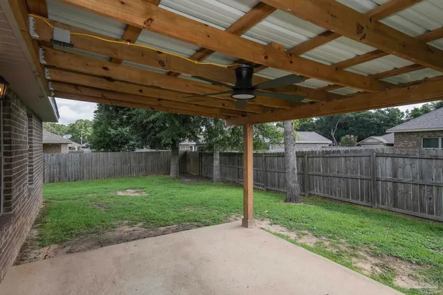 a view of a backyard with wooden fence