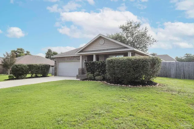 a front view of a house with yard and green space