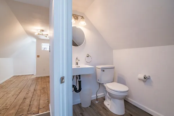 a bathroom with a toilet a sink and mirror