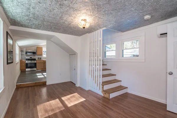 a view of a hallway with wooden floor and staircase