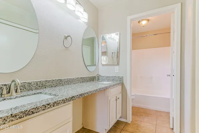 a bathroom with a granite countertop sink mirror and vanity