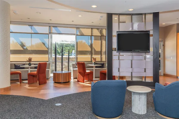 a front view of a building with a garden and trees