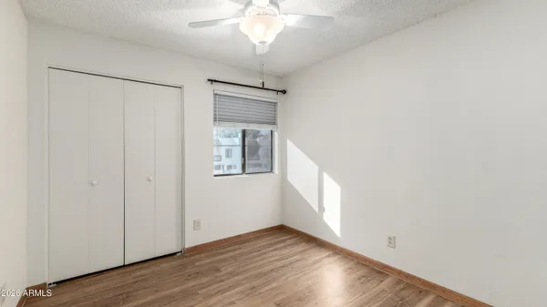 an empty room with a ceiling fan and a window
