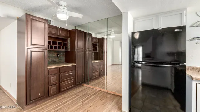 a kitchen with granite countertop a refrigerator and a stove top oven