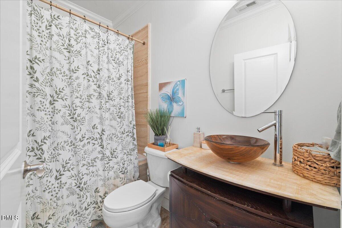 1304 Flying Hawk Road Apex, NC 27523 - Photo 19 of 52 a bathroom with a granite countertop sink a toilet and a mirror
