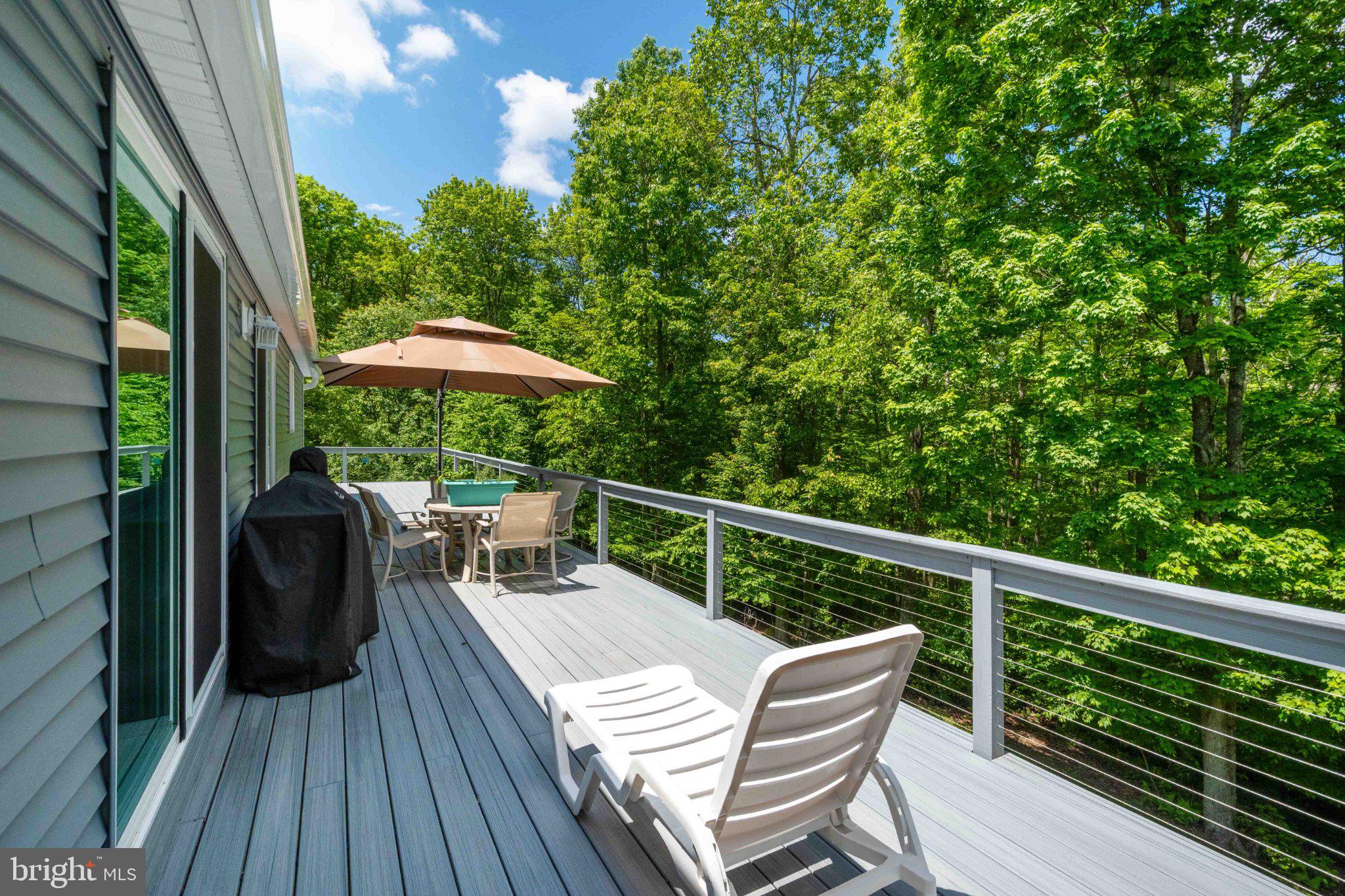 511 Hill Top Road Oakland, MD 21550 - Photo 14 of 51 Serene deck amidst lush greenery.