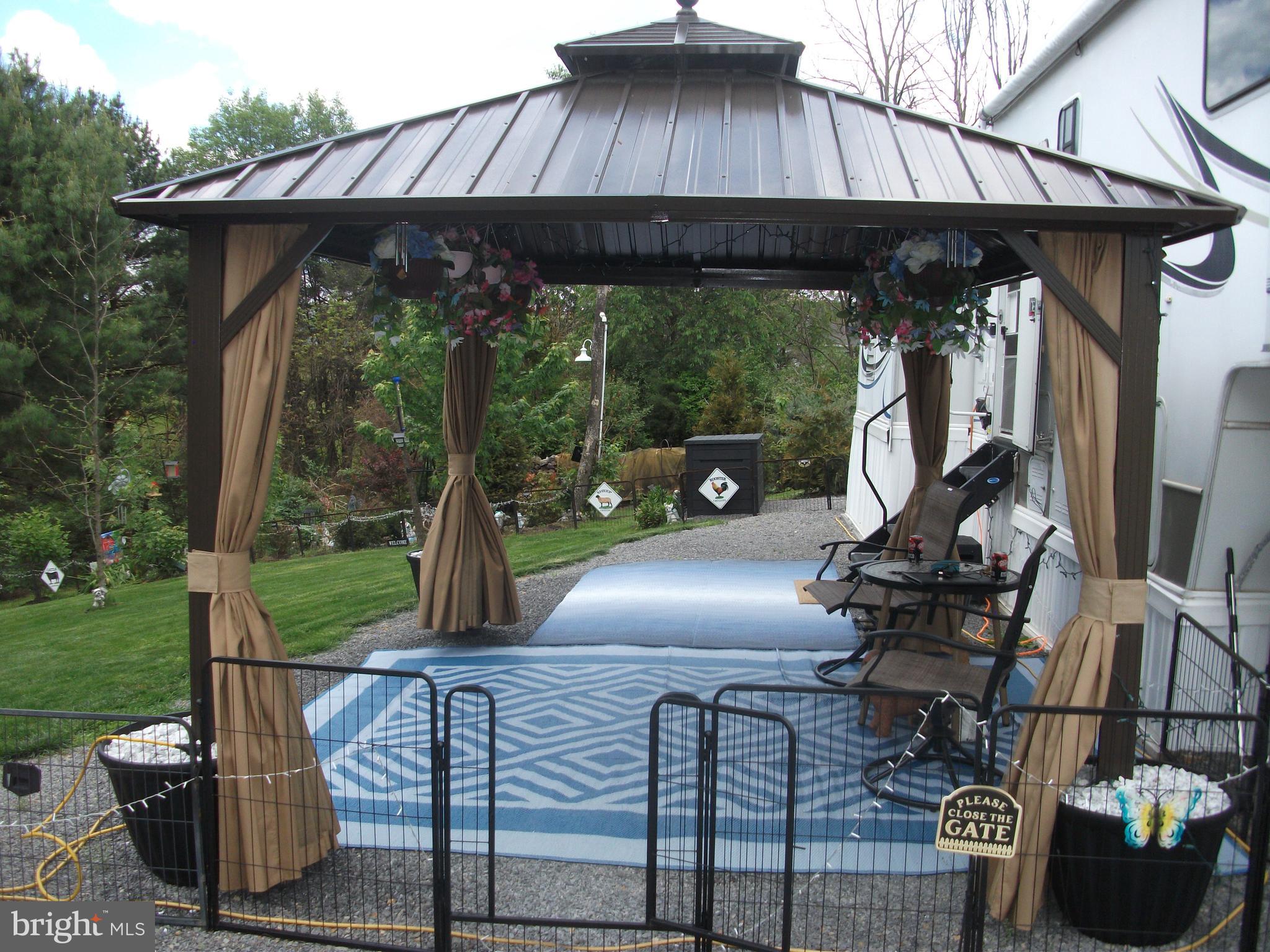 216 Garland Road Needmore, PA 17238 - Photo 38 of 38 a view of a patio with table and chairs under an umbrella with a small yard