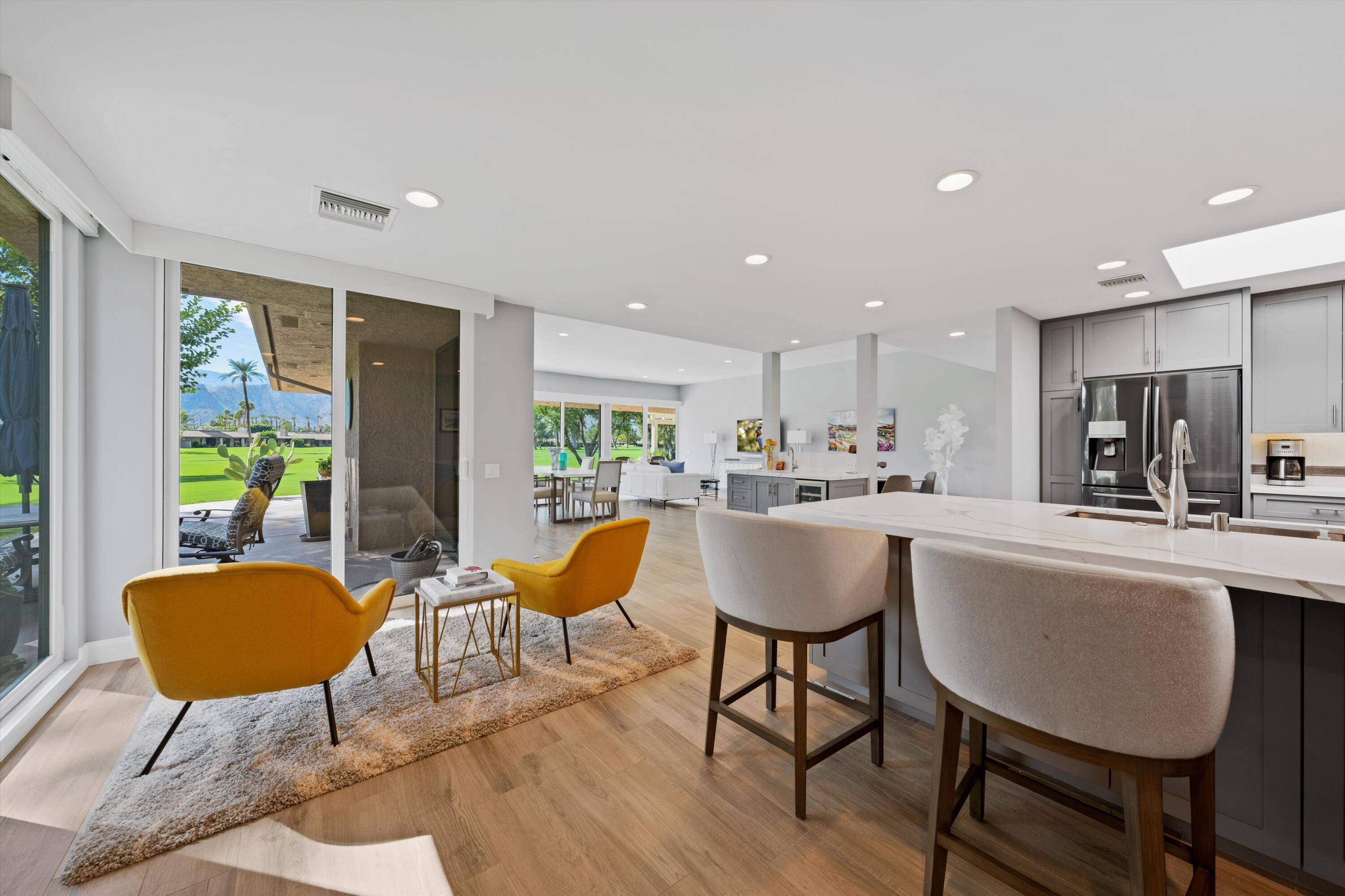 7 Wake Forest Court Rancho Mirage, CA 92270 - Photo 16 of 60 a kitchen with stainless steel appliances kitchen island granite countertop a dining table chairs and a refrigerator