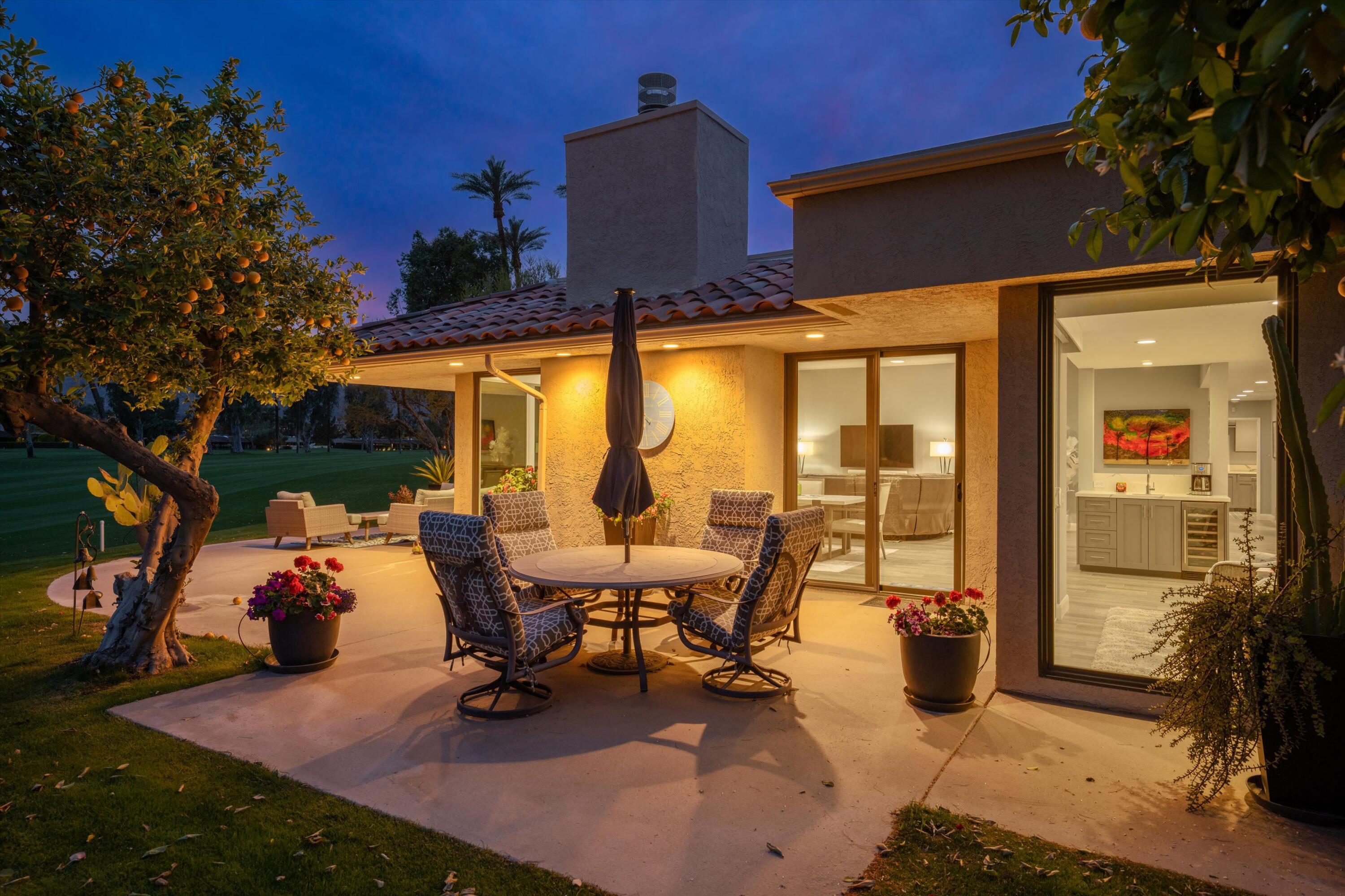 7 Wake Forest Court Rancho Mirage, CA 92270 - Photo 58 of 60 a view of a patio with table and chairs potted plants and a large tree