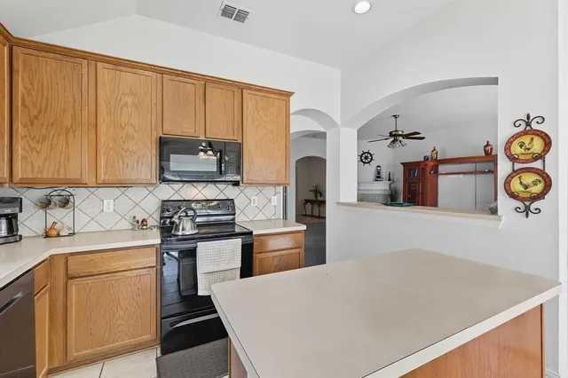 a kitchen with stainless steel appliances a stove microwave and sink