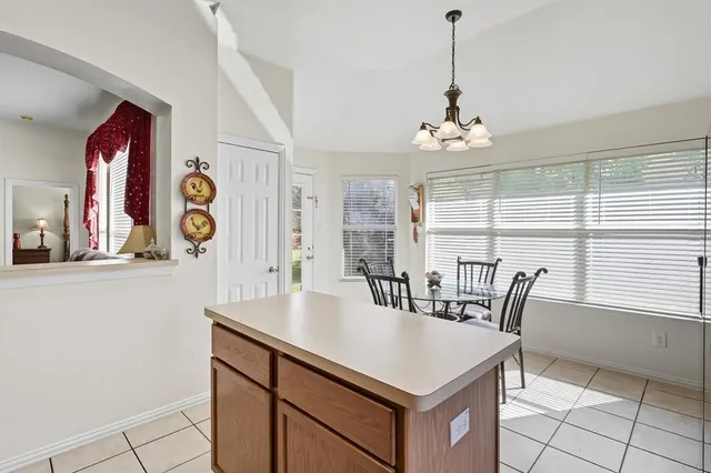 a kitchen with stainless steel appliances granite countertop a refrigerator a stove top oven a sink dishwasher a dining table and chairs with wooden floor