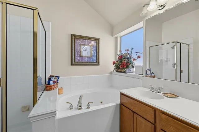 a bathroom with a double vanity sink mirror and bathtub