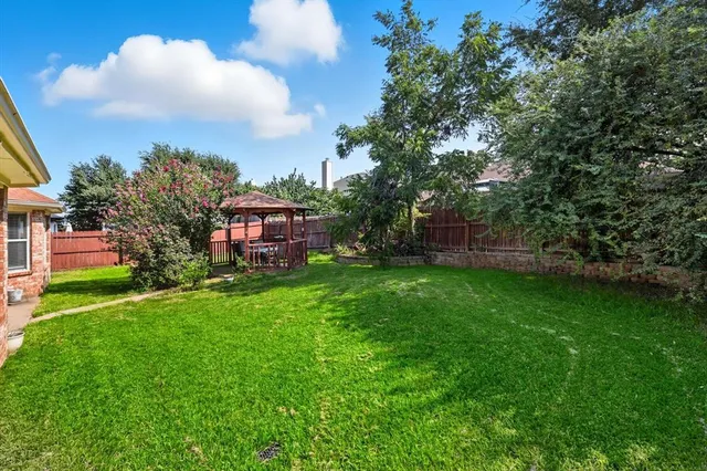 a view of a house with a yard and sitting area