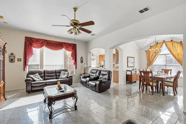 a living room with furniture a table and a large window