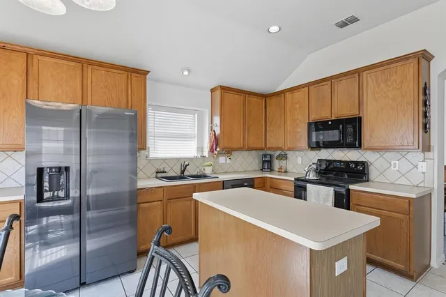 a kitchen with stainless steel appliances granite countertop a refrigerator a stove top oven a sink and dishwasher
