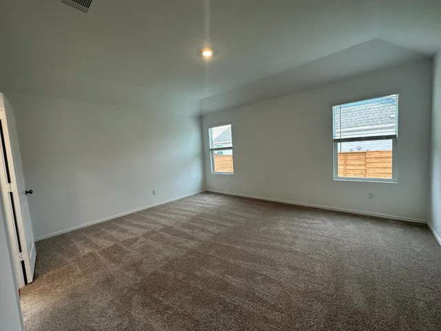 an empty room with a window and closet area