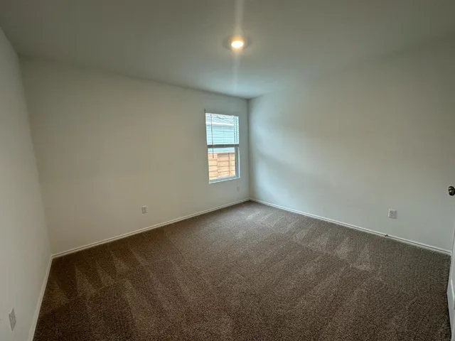 an empty room with closet and windows