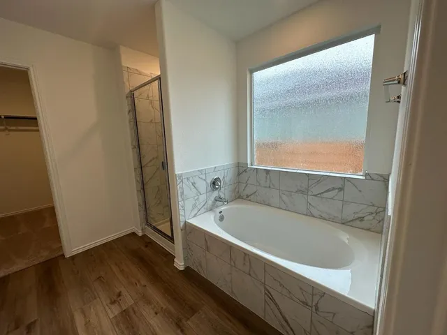 a spacious bathroom with a bathtub and a shower